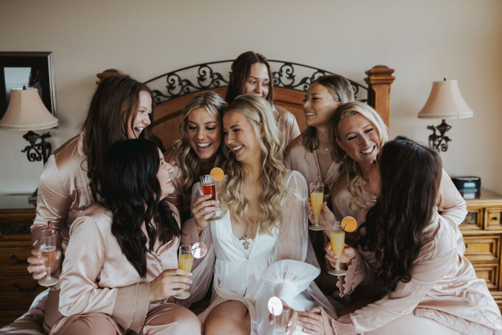 bride and bridesmaid toasting before getting ready for wedding